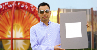 Xiulin Ruan, a Purdue University professor of mechanical engineering, holds up his lab’s sample of the whitest paint on record. (Purdue University/Jared Pike)